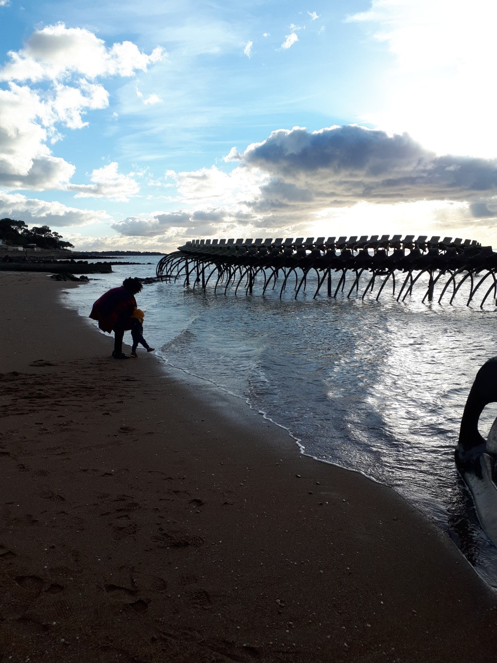 Edna joue avec Adao devant le serpent de mer